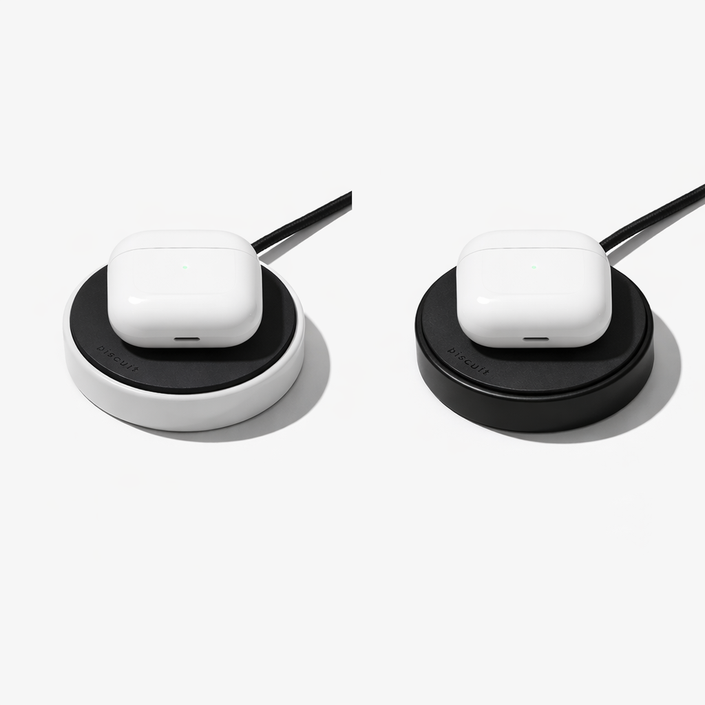 Two wireless earbuds on charging stands against a white background